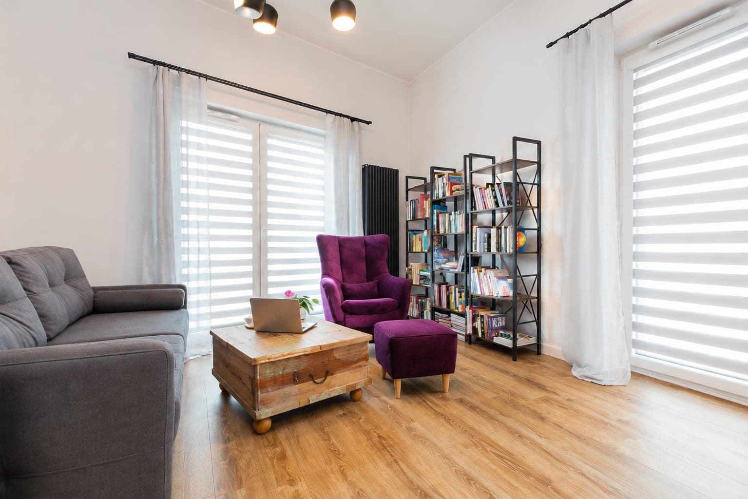 Living room with a grey sofa, purple armchair and bookcase, apartment on Jana Kazimierza in Wola, Warsaw