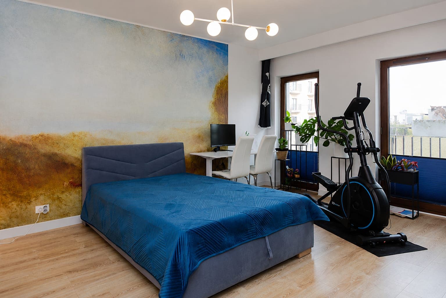 Bedroom with a painted landscape behind the bed, apartment on Sierakowskiego in Praga-Północ, Warsaw